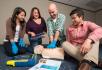 A group of people learning CPR.