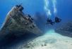 Divers swimming towards a wreck.