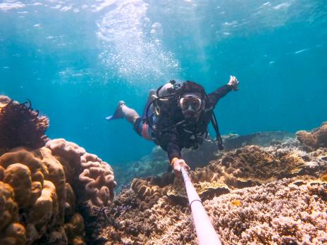 PADI AmbassaDiver Aakash Malhotra taking a selfie while scuba diving underwater.