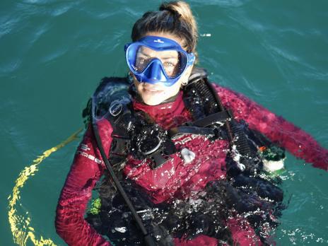 PADI AmbassaDiver Luciana Maldonado about to get ready to scuba dive in the water.