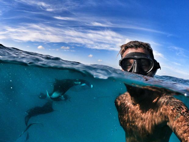Siraj Ahmed taking a selfie on the water surface with manta rays