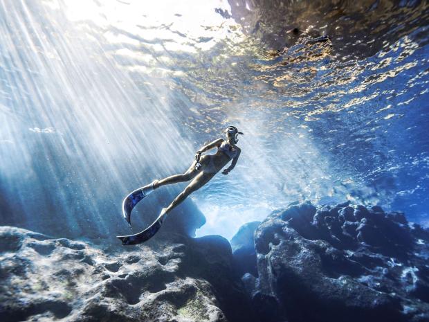 A photogenic Kelly Han as she dives underwater as the sun rays glimmer