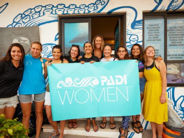 Group of women holding up a PADI Women sign.