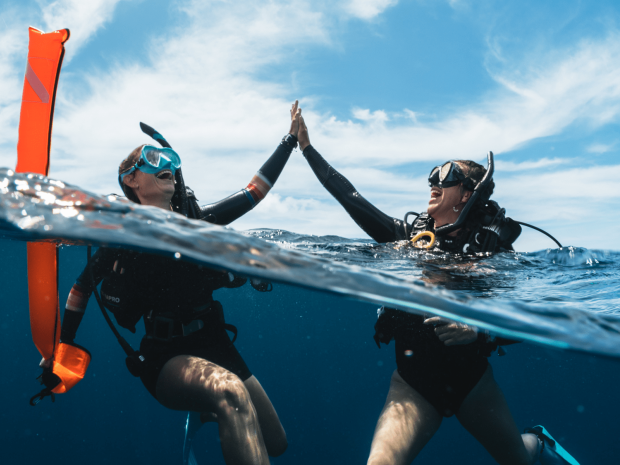 two divers give each other a high five