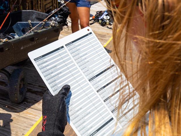 person looking at a sheet for marine debris