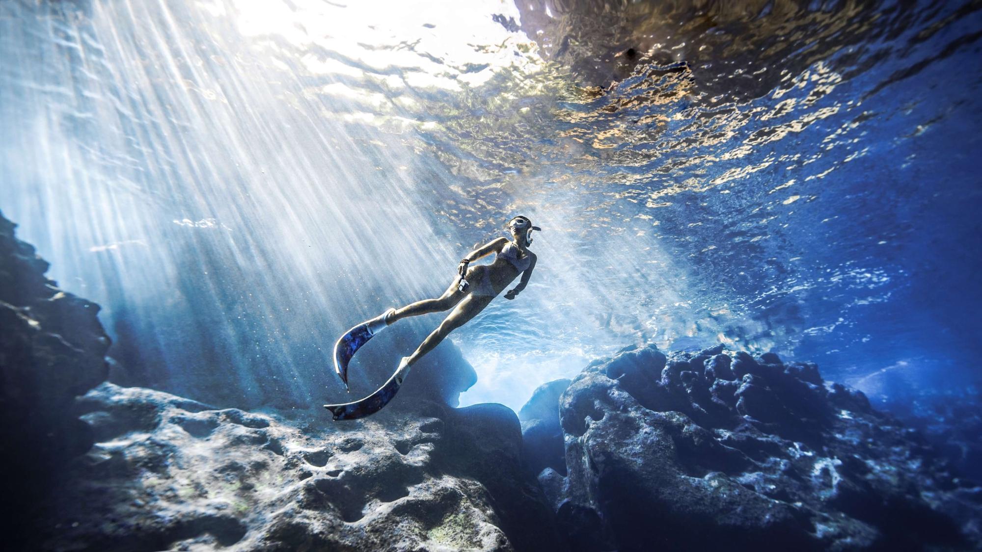 A photogenic Kelly Han as she dives underwater as the sun rays glimmer