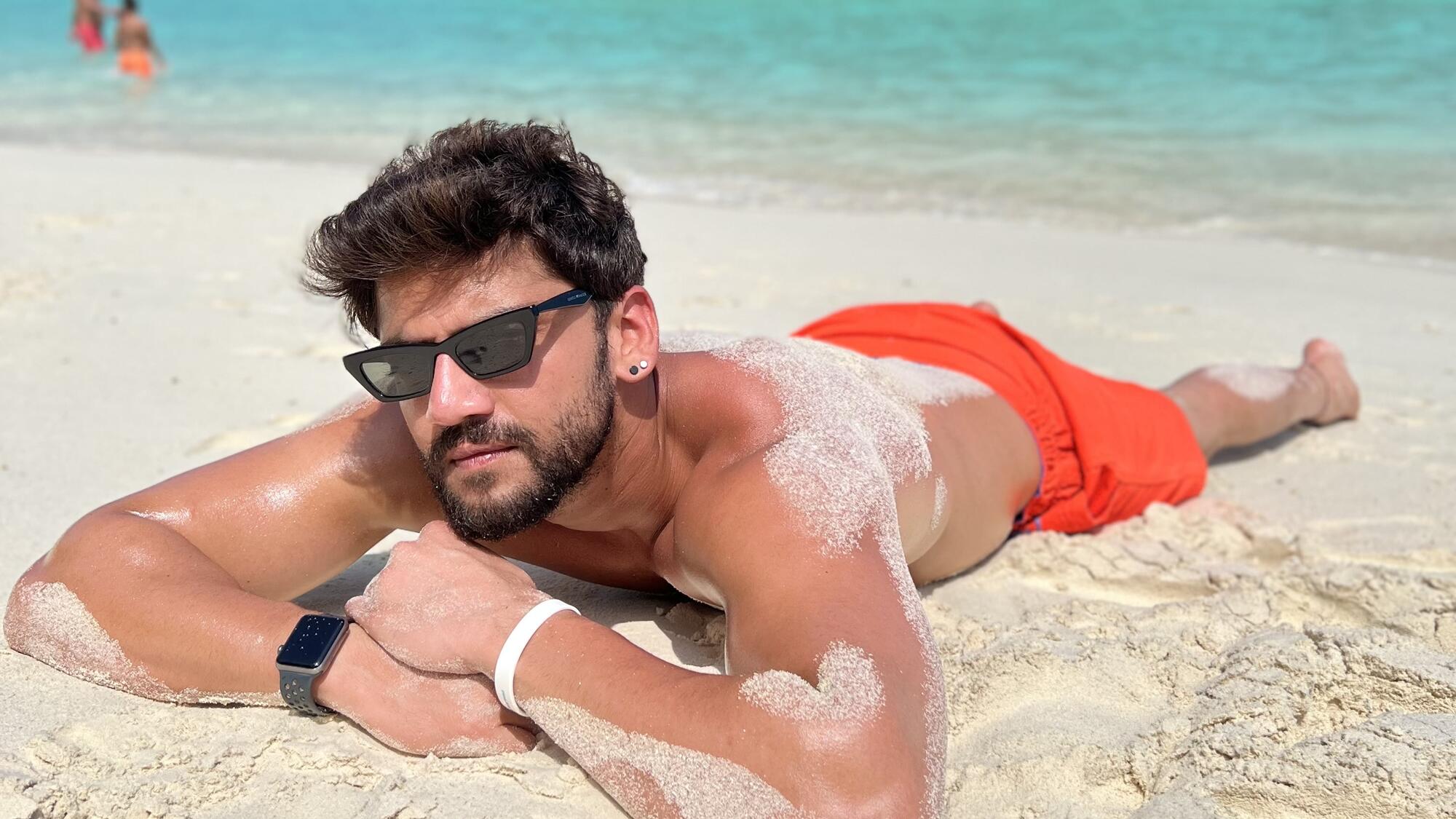 Zaheer Iqbal laying down on the beach.